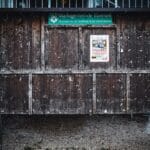 Drewniana, postarzana tablica ogłoszeń z przyczepionymi plakatami