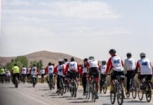 Grupa rowerzystów w strojach sportowych na malowniczej trasie wśród wzgórz